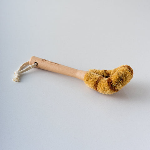 "天然椰棕清潔刷細節圖" - 顯示刷子的天然椰棕纖維,突出其環保特性和對無塗層鍋的溫和清潔效果。展示了其堅固耐用的設計,握感舒適的手柄,以及適合各種廚房清潔任務的多功能性。